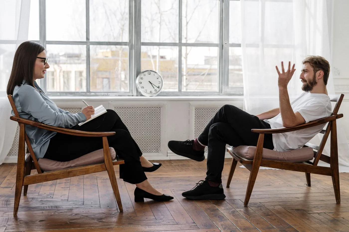 Two people having a face-to-face conversation in a bright room.